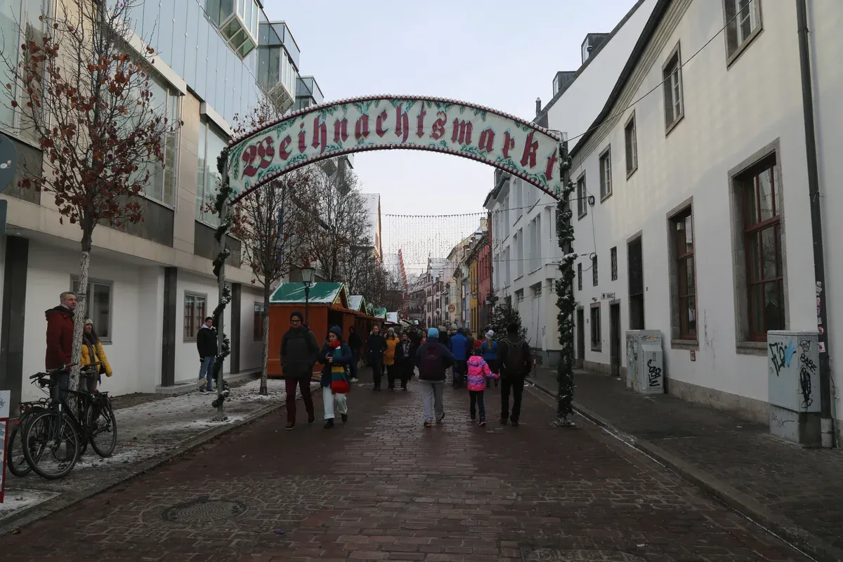 Weihnachtsmarkt arch over a pedestrian street in Freiburg with stalls beyond