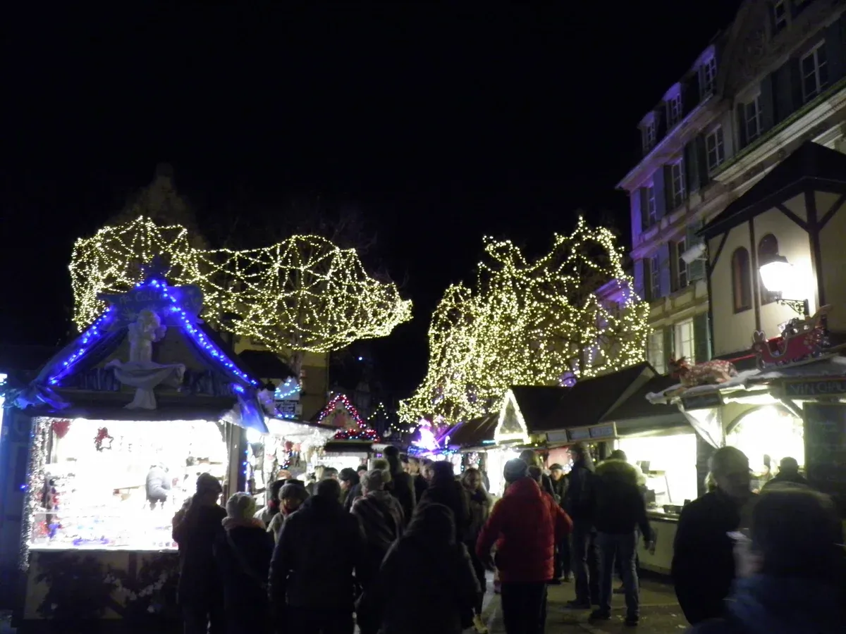 Lit Christmas stalls and light sculptures on Place Jeanne-d'Arc in Colmar at night