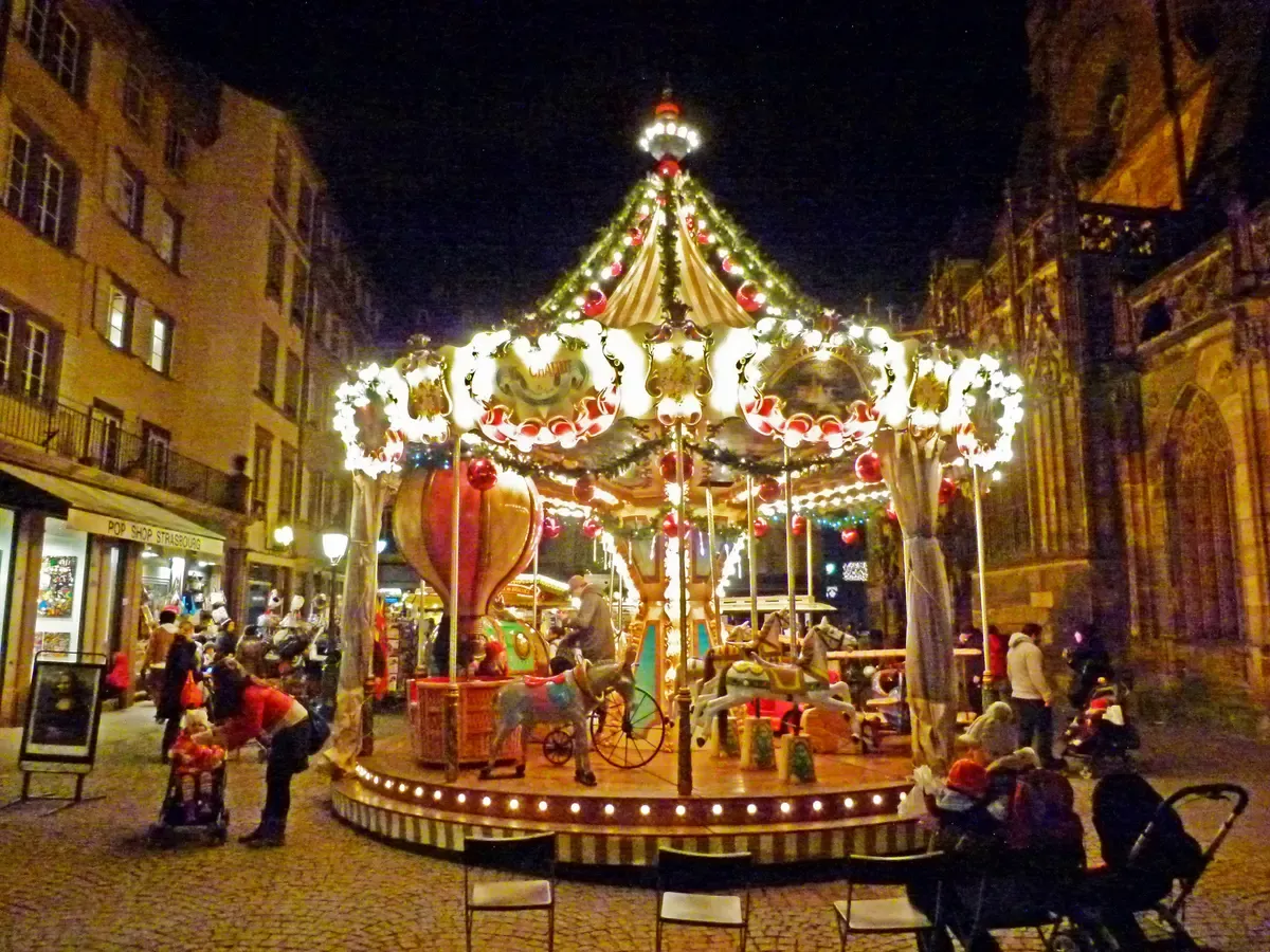 Carousel lit at night on the Strasbourg Christkindelsmärik near the cathedral